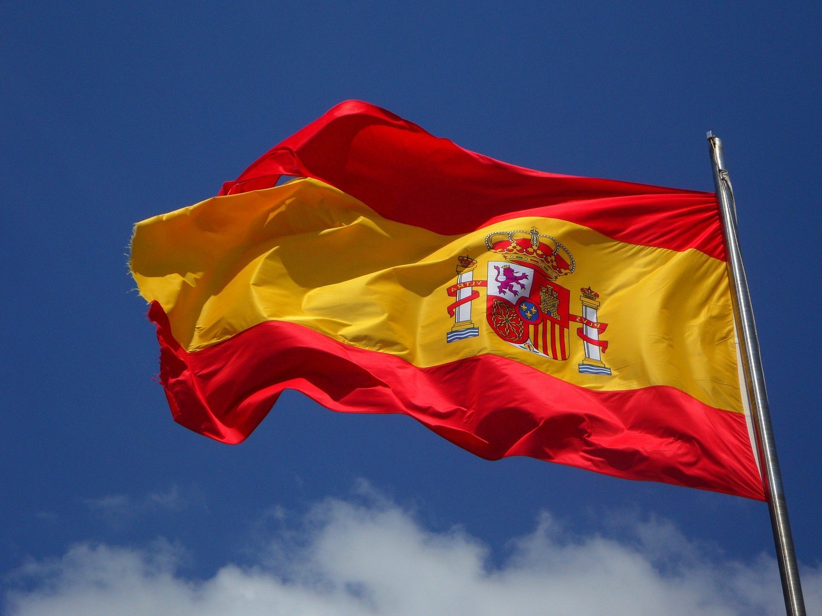 Flag of Spain featuring red and yellow horizontal stripes with the national coat of arms.